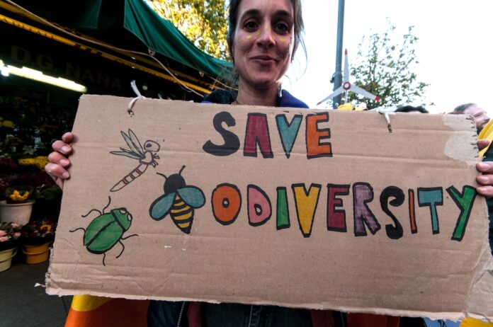People wear animal masks and hold signs and banners as they participate in the street parade for the Climate Pride in Rome, Italy
