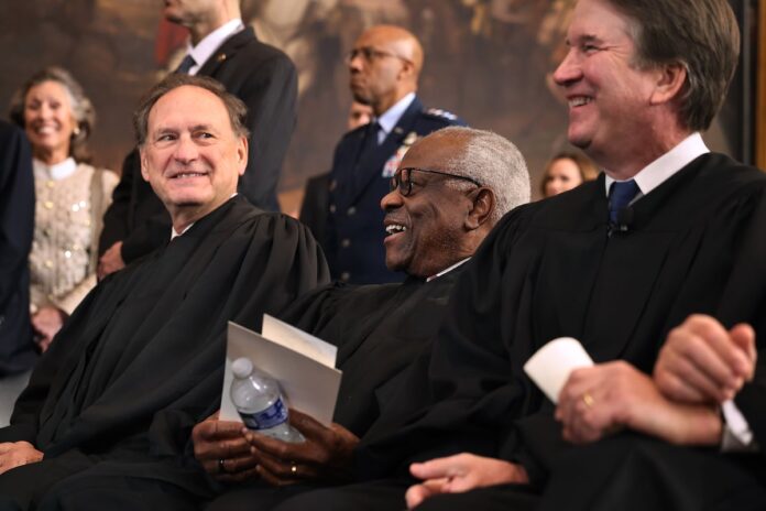 U.S. Supreme Court Associate Justices Samuel Alito, Clarence Thomas and Brett Kavanaugh share a laugh while waiting for their opportunity to leave the stage at the conclusion of the inauguration ceremonies in the Rotunda of the U.S. Capitol in Washington, DC