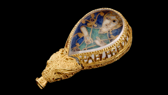a gold bezel with inscription around the edges holds a cloisonne gemstone depicting a man